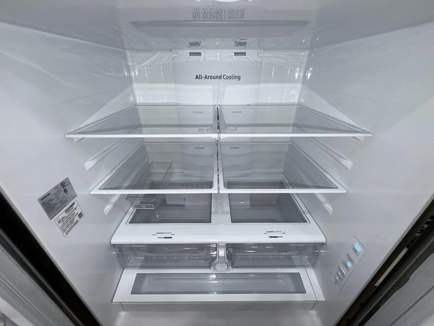 Inside of a fridge, emptied and wiped clean