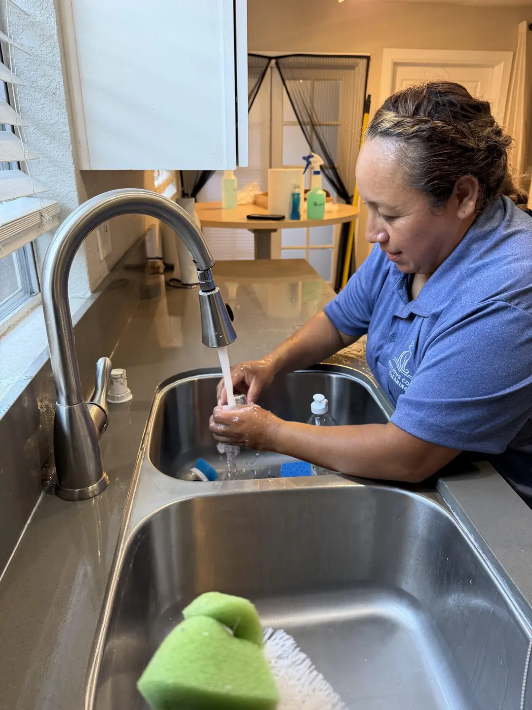 Our cleaner rinsing a kitchen sink during a house cleaning
